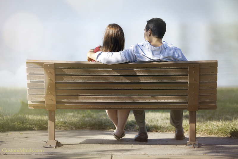 husband and wife relaxing on bench by sugarland lake