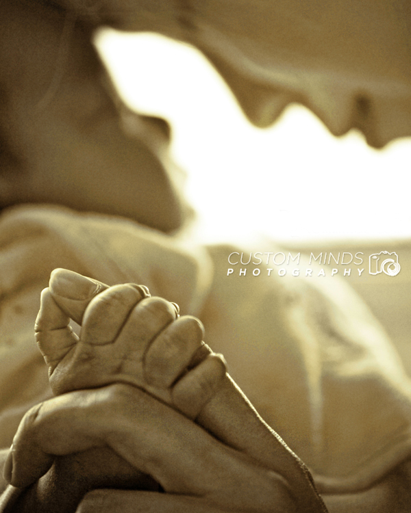 baby holding moms finger