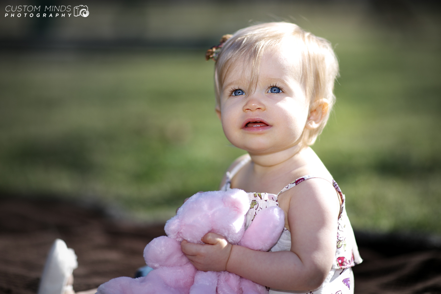 child in the park with pink bear