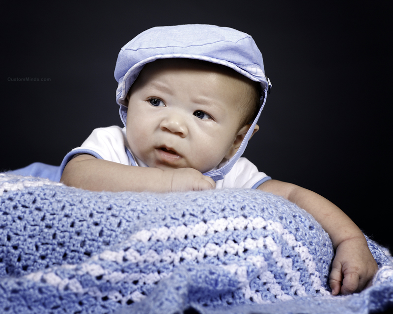 baby with blue blanket and hat