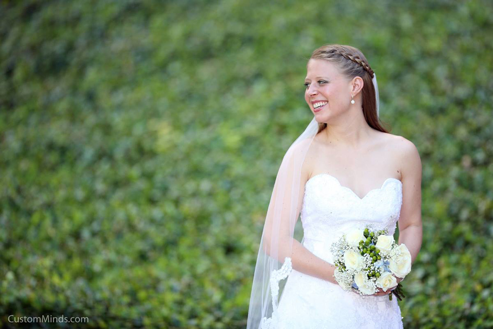 Bride posing by a patch of greenery by the Houston Grand Opera.