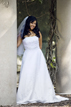 Smiling bride standing by pillars at Hermann Park in Houston Texas