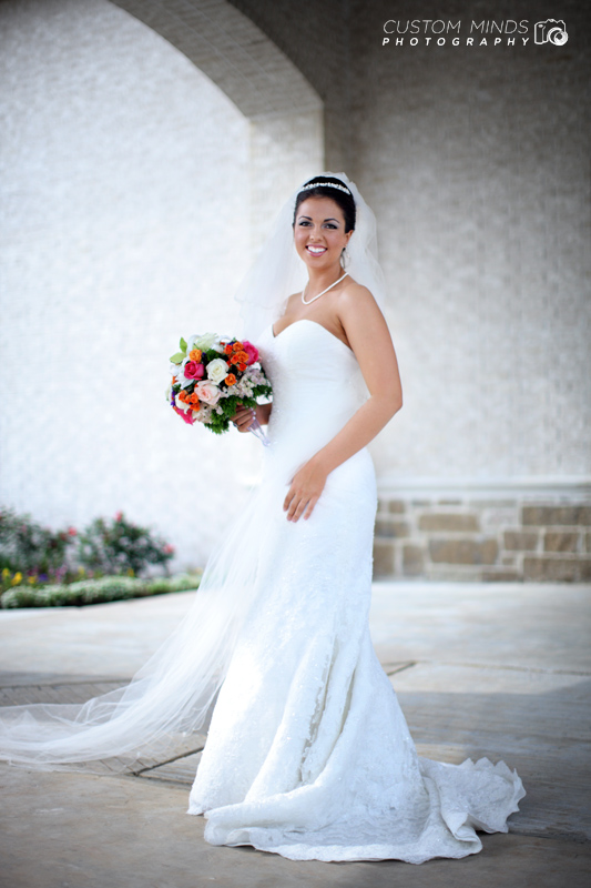Smiling bride standing by pillars at a church in the Woodlands Texas